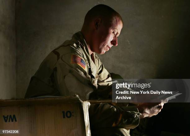 Pfc. Derek Garrity of the Army's 82nd Airborne Division, who is from Queens, N.Y., looks at photos sent to him by his mother at Forward Operating...