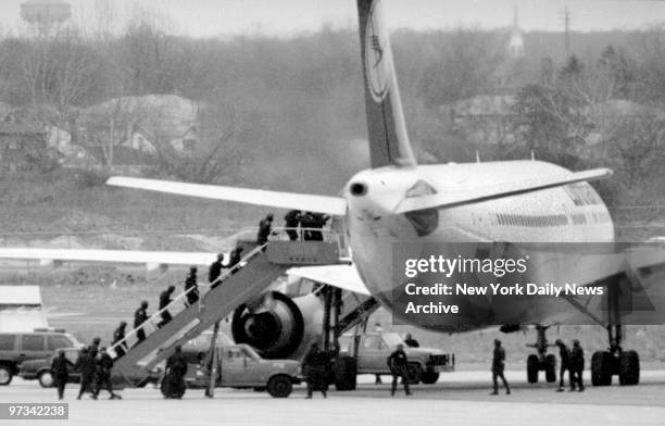 Police and FBI run up steps of hijacked Lufthansa place after landing.