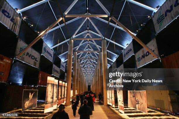 People walk through the photo exhibit "Ashes and Snow" in the Nomadic Museum, a 45,000 square-foot temporary structure made from cargo containers, at...