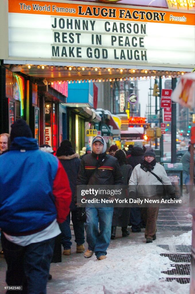 Pedestrians make their way past the Laugh Factory on Eighth