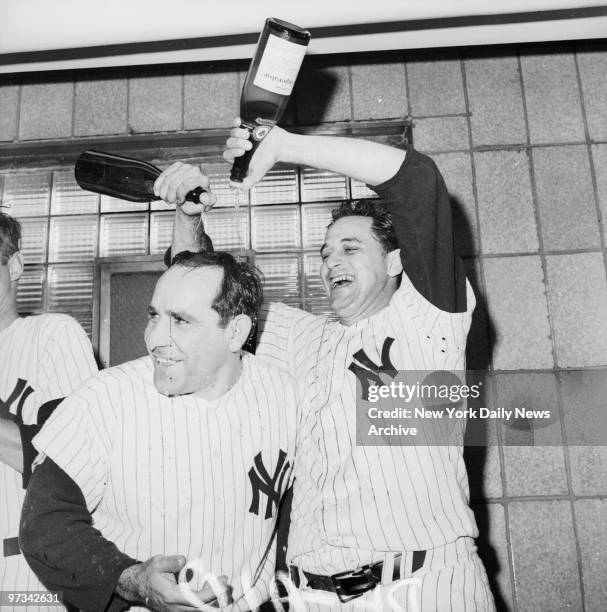 Pedro Ramos, who gave Yogi Berra considerable relief during the heat of the pennant chase, pours champagne over manager Yogi after the game in the...