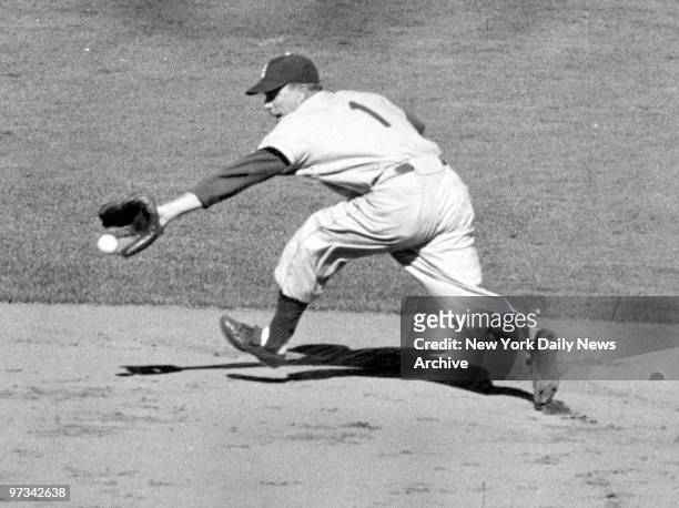 Pee Wee Reese of the Brooklyn Dodgers takes a six-inning hit away from Phil Rizzuto of the New York Yankees with a running back-handed stop of...