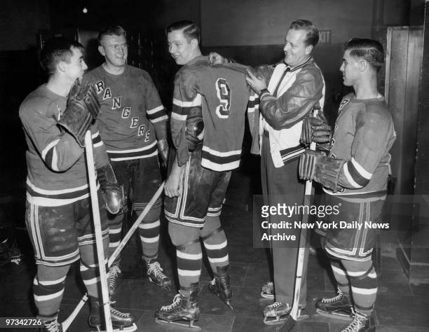 Pentti Lund , who now wears No. 9, gets measured for size by New York Rangers' coach Lynn Patrick, who used to wear the No. 9 jersey. Looking on in...