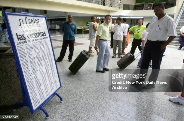 People at Santo Domingo's Las Americas International Airport gather around a list of victims of American Airlines flight 587. The Airbus A300 went...