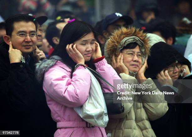 People cover their ears as firecrackers explode during Chinese New Year celebrations at Chatham Square in Chinatown. Today marks the beginning of the...