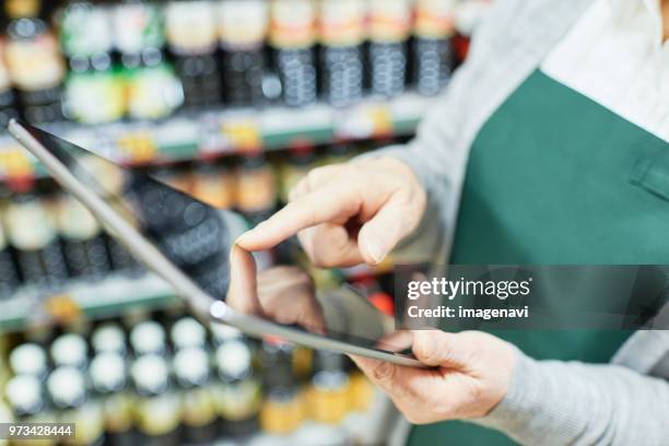 senior woman checking restock in supermarket - restock stock pictures, royalty-free photos & images