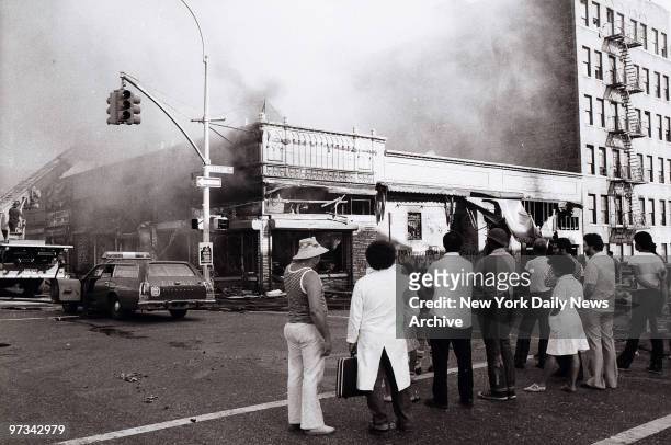 People look on on as firemen put an end to arsonist's handiwork on Marmion Ave. In Brooklyn during the aftermath of the blackout of 1977.