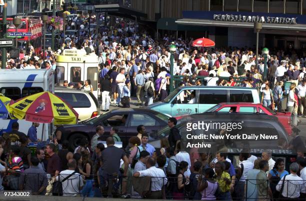 People mill around Eighth Ave. After Penn Station was closed due to a massive power failure that caused the largest power outage in the nation's...