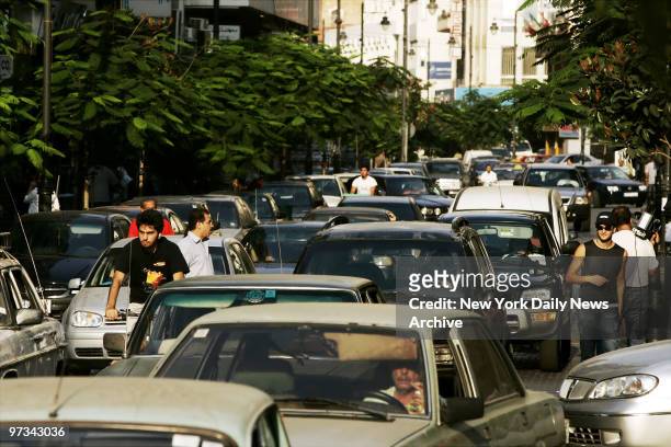 People sit in traffic in central Beirut, which unlike the devastated southern areas of the city, has avoided air strikes by Israel.