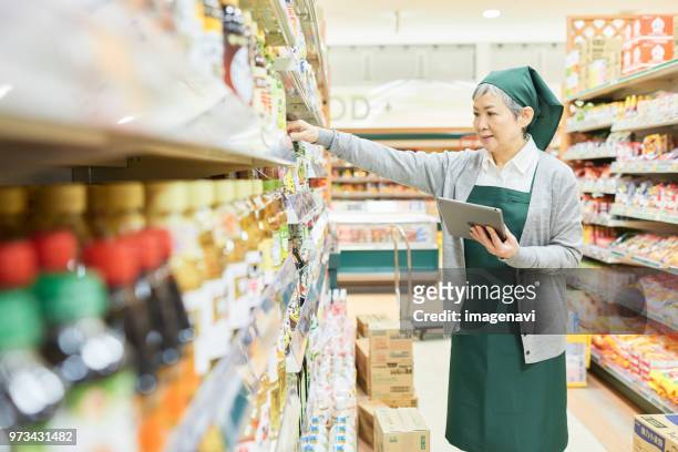 senior woman checking restock in supermarket - restock stock pictures, royalty-free photos & images