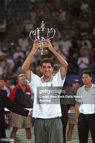 Pete Sampras raising trophy above his head after defeating Michael Chang to win U.S. Open.