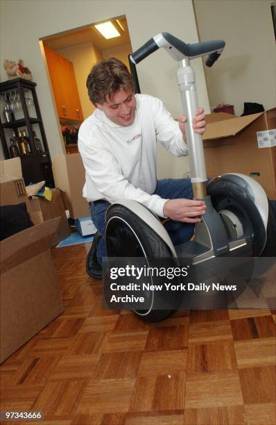 Peter Shankman attaches the shaft and handles to the wheels as he assembles his new Segway Human Transporter in his apartment. The new...