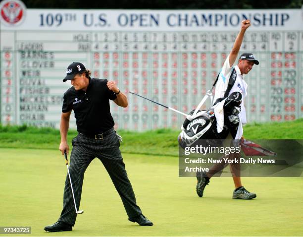 Phil Mickelson and caddie Jim "Bones" MacKay celebrate after Mickelson makes a birdie putt on the 18th hole during 3rd round play at at the U.S. Open...