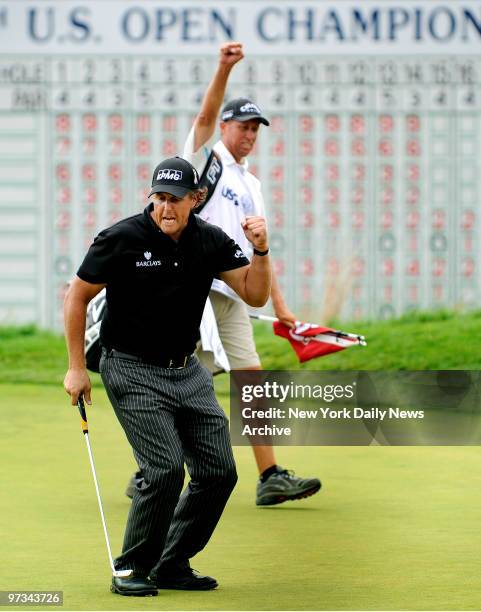 Phil Mickelson and caddie Jim "Bones" MacKay celebrate after Mickelson makes a birdie putt on the 18th hole during 3rd round play at at the U.S. Open...