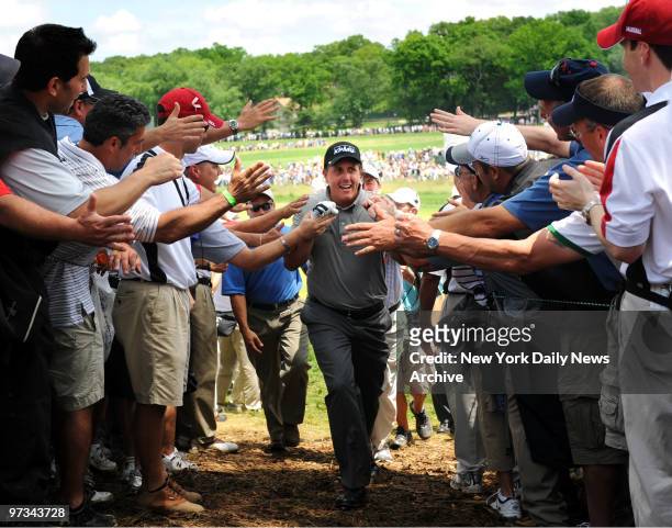 Phil Mickelson gets high fives from fans as he walks up to the 18th hole during his 1st round at the U.S. Open golf championship on the Black Course...