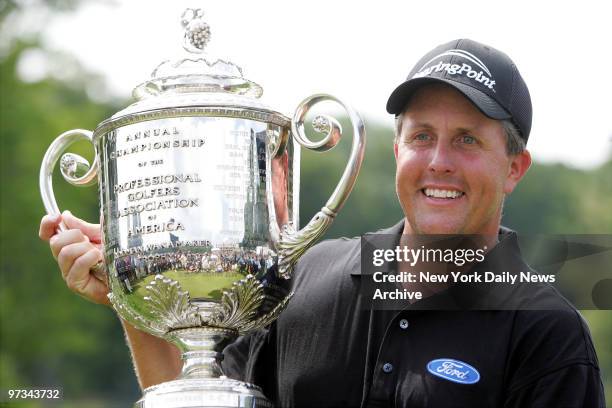 Phil Mickelson holds up the Wanamaker Trophy after winning the 87th PGA Championship at Baltusrol Golf Club in Springfield, N.J.