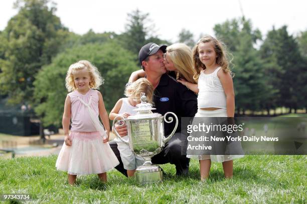 Phil Mickelson kisses his wife, Amy, as they celebrate with their children Sophia, Evan and Amanda after he won the 87th PGA Championship at...