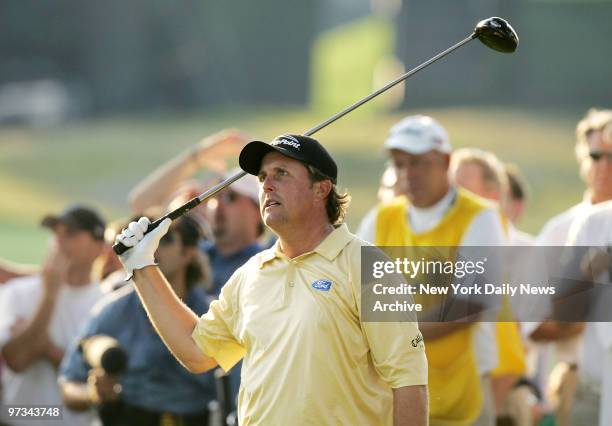 Phil Mickelson of the United States watches as his ball heads for the trees after teeing off to start the 18th hole during the final round of the...