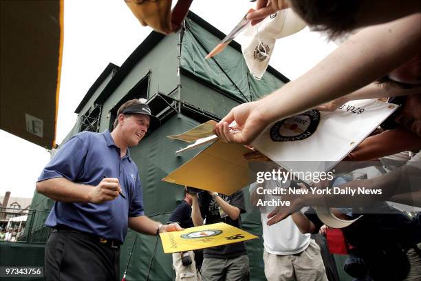 Phil Mickelson signs autographs for fans after finishing his practice round at the 87th PGA Championship at Baltusrol Golf Club in Spingfield, N.J.