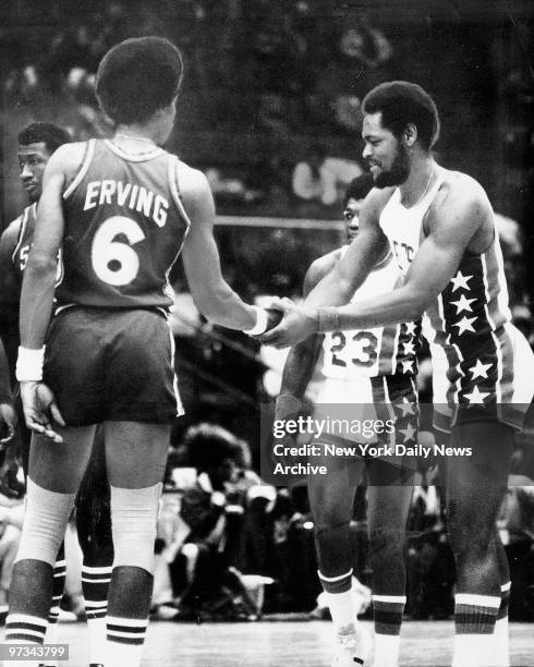 Philadelphia 76ers Julius Erving shakes hands with ex-teammates Tim Bassett of the N.J. Nets as John Williamson waits his turn.