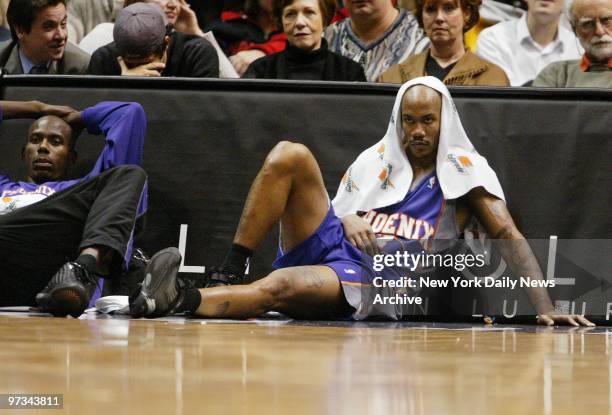 Phoenix Suns' Stephon Marbury doesn't look happy as he sits on the sidelines with Bo Outlaw during a game against the New Jersey Nets at Continental...