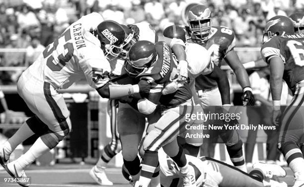 Philadelphia Eagles' Wilbert Montgomery is stopped by New York Giants defenders Harry Carson, left, and Jim Burt, right, during first quarter action...
