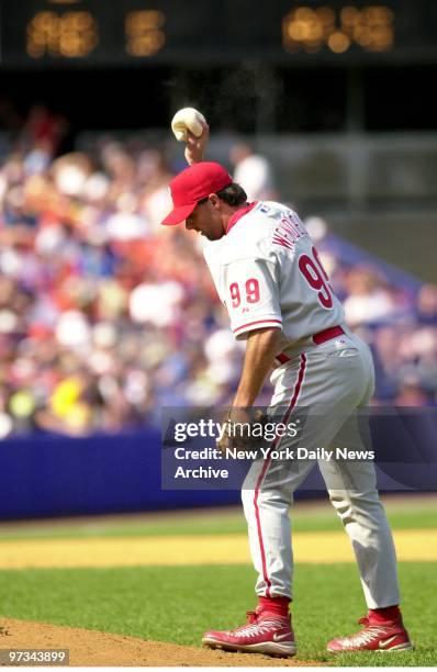 Philadelphia Phillies pitcher Turk Wendell, traded to the Phillies from the New York Mets just last night, tosses rosin bag as he takes the mound...