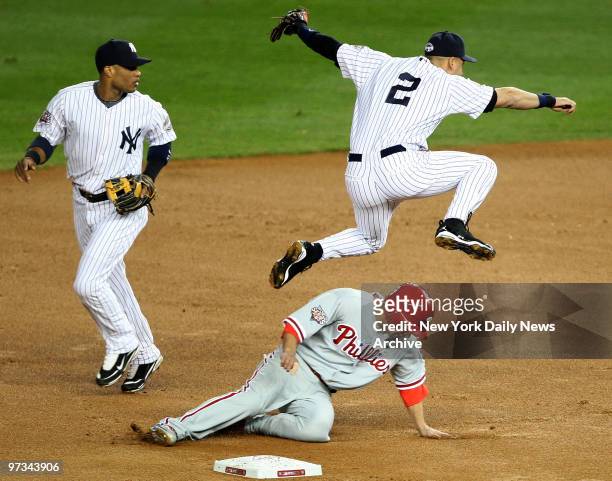 Philadelphia Phillies' Raul Ibanez slides under New York Yankees' Derek Jeter as he makes the throw to first to comlete the double play in the sixth...