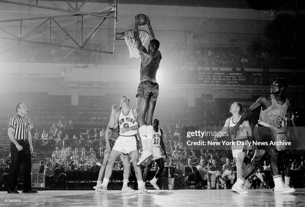 Philadelphia Warriors' Wilt Chamberlain stretches and dunks