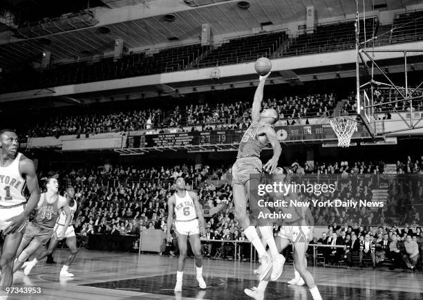 Philadelphia's mightiest Warrior, Wilt "The Stilt" Chamberlain, baffles Knickerbocker defender Phil Jordan at Madison Square Garden. He's picking off...