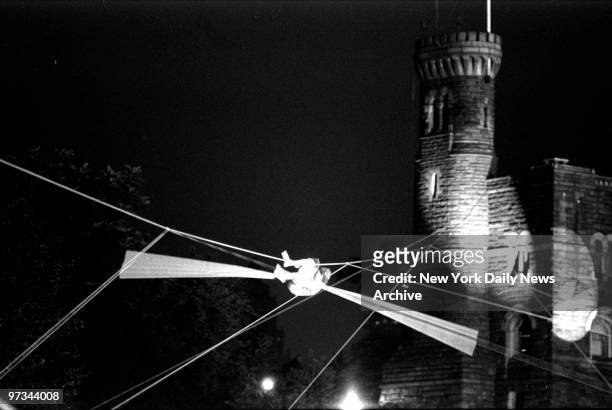 Philippe Petit performs on high wire above Central Park Lake, with Belvedere Castle in the background.