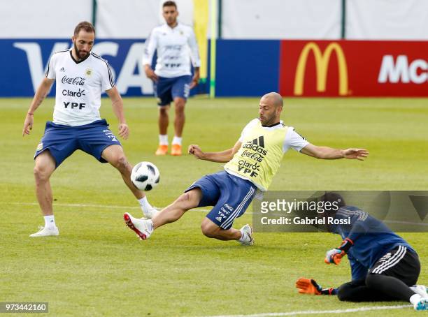 Javier Mascherano of Argentina struggles for the ball with Gonzalo Higuain during an open to public training session at Bronnitsy Training Camp on...