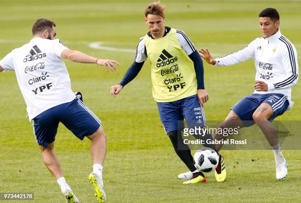 Lucas Biglia of Argentina fights for the ball with Marcos Rojo and GOnzalo Higuain of Argentina during an open to public training session at...