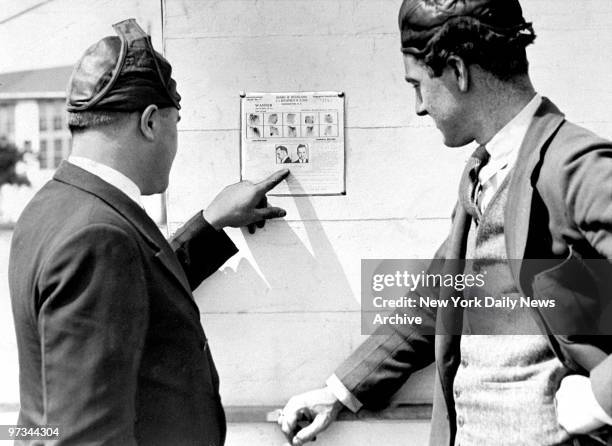 Pilots Paul Herman and Bill Ward look at poster of John Dillinger.