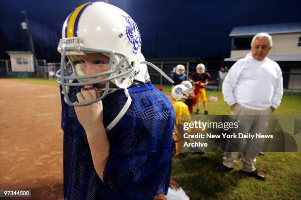 Player Carl Gipson looks on as members of the Bay-Waveland Youth Football League Gold Tigers and Lightning Quick Blue Tigers practice on their...