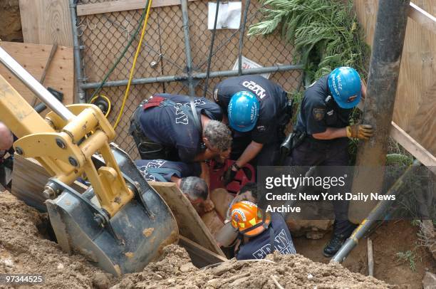 Police and Fire Department emergency workers extricate Luis Mina, who was buried alive when a construction trench caved in on him at St. Marks Ave....