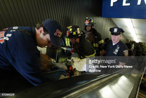 Police and Fire Department rescue workers carry a man from Penn Station after he was hurt when a virtually empty Amtrak train heading into the...