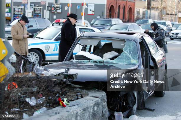 Police look over the scene at West and Canal Sts. In Manhattan where a BMW ran into the median around six o'clock Saturday morning, killing the...