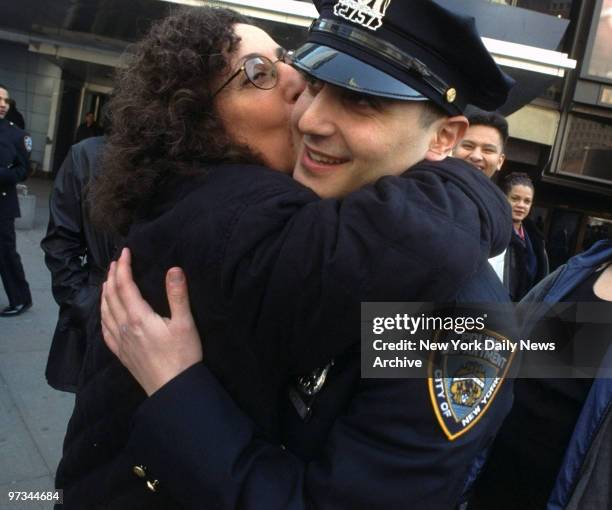 Police Academy graduate Jason Andreula gets a hug and a kiss from his mother, Ada, as his family looks on outside Madison Square Garden. Andreula,...