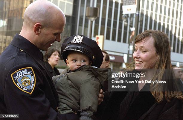 Police Academy graduate Samuel Santangelo tries his new hat on his 6-month-old son, Colin, as his wife, Valerie, looks on outside Madison Square...