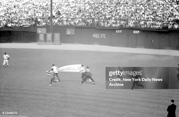 Police chase partisans who leaped from stands at Yankee Stadium to unfurl anti-Castro banner. Incident occured in opener of twin-bill watched by...