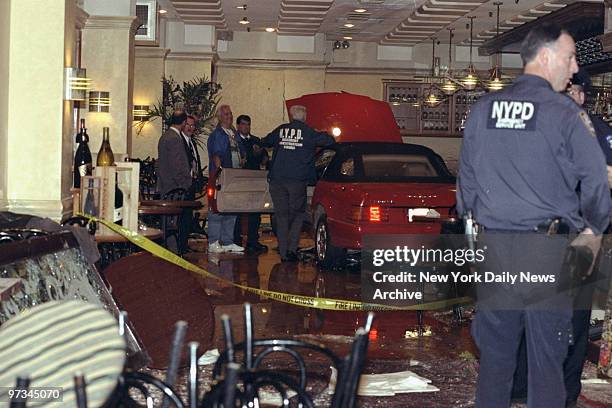 Police inspect Mercedes convertible that went out of control, crashed through the front window and hurtled 30 feet into Arno Ristorante on W. 38th...