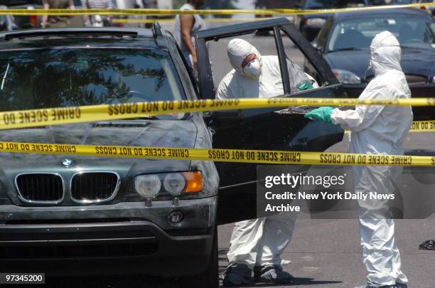 Police investigators checks a stolen BMW for fingerprints and other forensic evidence after it was abandoned at Lefferts and Kingston Aves. In Crown...