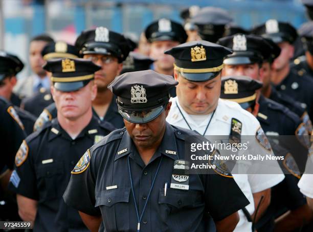 Police officers bow their heads during a moment of silence held at Yankee Stadium honoring fellow officer Eric Concepcion who was allegedly struck...