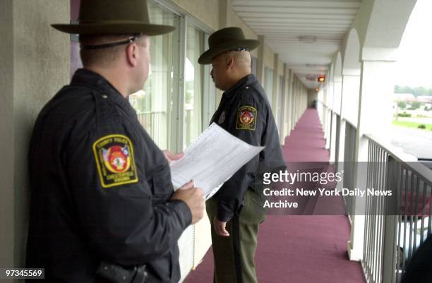 Police officers check rooms at a Day's Inn motel across from the Ponderosa steakhouse in Ashland, Va., where a man was shot Saturday night....