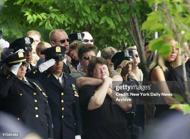 Police officers give salute as grieving mourners look on outside a New Hyde Park, L.I., funeral home as the body of NYPD Sgt. Erin O'Reilly is...