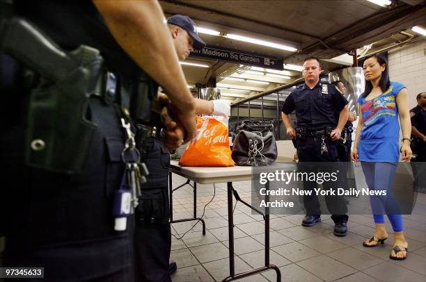 Police officers search the bag of Jessie Jian, of Brooklyn, at the Herald Square subway station on W. 34th St. As security is increased in the city...