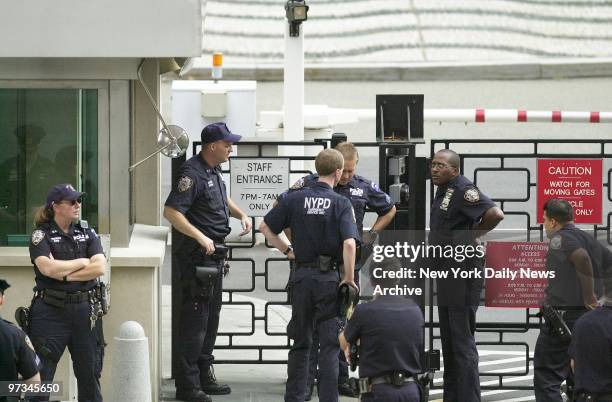 Police officers stand outside the main entrance to the United Nations building after a postal worker from Illinois hopped a fence and fired at least...