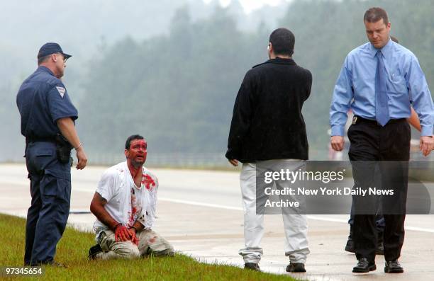 Police officers stand over a bloodied Miguel Carrasquillo on Interstate 40 near Fayetteville, N.C. Carrasquillo, who allegedly kidnapped his wife,...