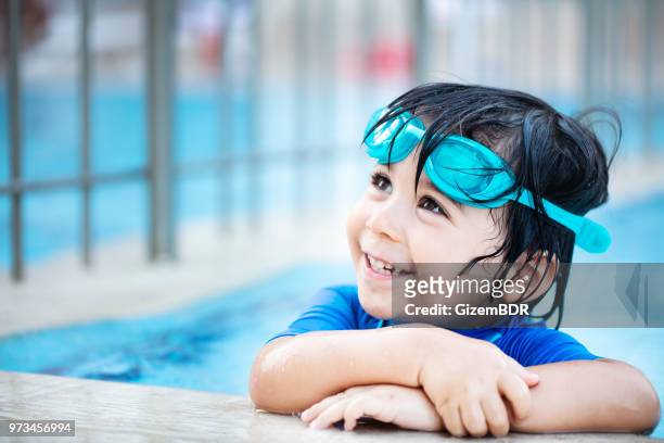 gelukkige jongen genieten van zomertijd in zwembad - leren zwemmen stockfoto's en -beelden